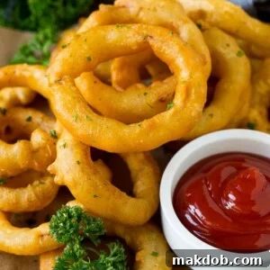 Fried onion rings on a plate with a side of ketchup.