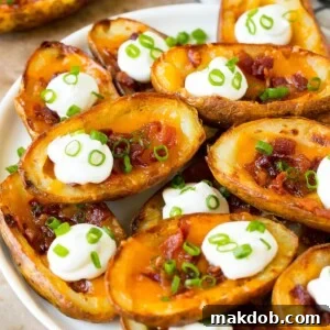 A serving plate of potato skins topped with bacon and sour cream.