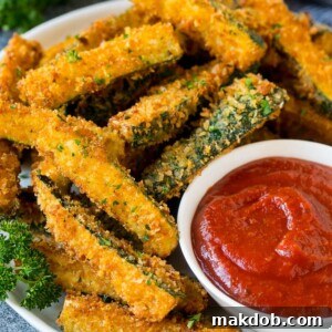A p late of fried zucchini served with marinara for dipping.