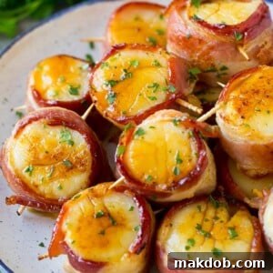 Bacon wrapped scallops coated in glaze and topped with parsley.