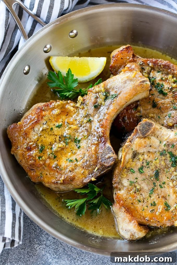 Perfectly seared brown sugar pork chops glistening in a rich garlic butter sauce, topped with fresh herbs in a cast iron skillet.