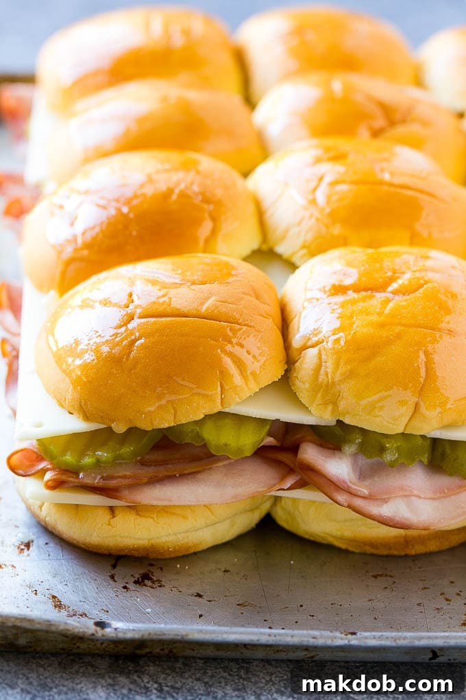 Assembled slider sandwiches, brushed with garlic butter, ready to go into the oven.