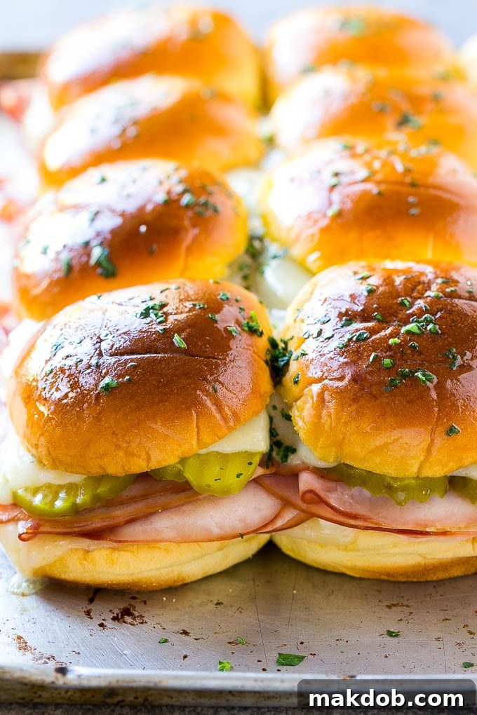 A sheet pan of golden-brown Cuban slider sandwiches, fresh from the oven.