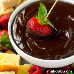 A strawberry on a skewer dipped into a bowl of chocolate fondue.