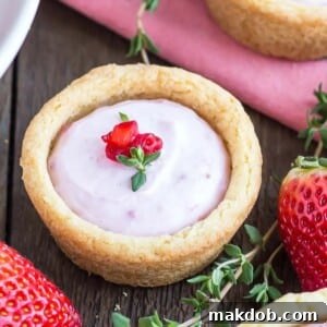 A picture of a cookie cup with a strawberry cheesecake filling.