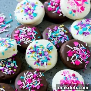 Chocolate covered Oreos decorated with pink and purple sprinkles.