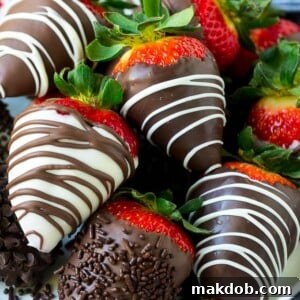 A plate of chocolate covered strawberries dipped in white and dark chocolate.