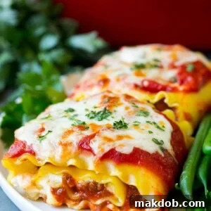 Lasagna roll ups with meat sauce, served with a side of green beans.