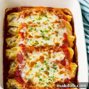 A dish of baked manicotti pasta, topped with melted cheese and fresh parsley.