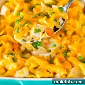 A spoon serving up a portion of cheesy turkey casserole.