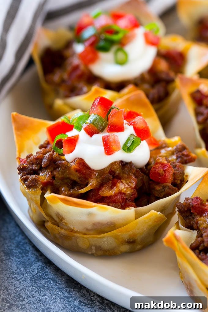Taco Cups Recipe | Wonton Taco Cups | Taco Cupcakes | Mexican Appetizer #taco #hamburger #appetizer #dinneratthezoo #beef Taco cupcakes layered with wontons, seasoned meat and cheese, then baked to perfection.