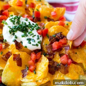 Irish nachos loaded with cheese, bacon, sour cream, tomatoes and chives.