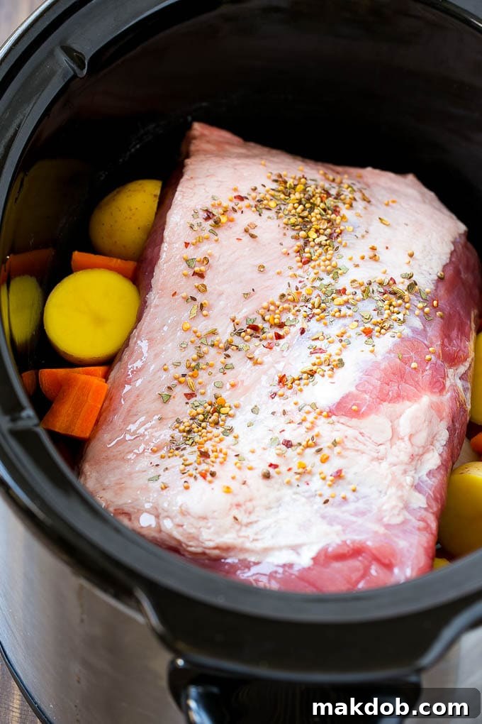 Slow Cooker Corned Beef Recipe | Crock Pot Corned Beef | Corned Beef and Cabbage #beef #cornedbeef #cabbage #potatoes #carrots #stpatricksday #irish #dinneratthezoo A corned beef roast in a slow cooker with carrots and potatoes.