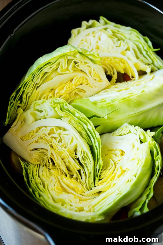 Slow Cooker Corned Beef Recipe | Crock Pot Corned Beef | Corned Beef and Cabbage #beef #cornedbeef #cabbage #potatoes #carrots #stpatricksday #irish #dinneratthezoo Cabbage wedges inside a crock pot.