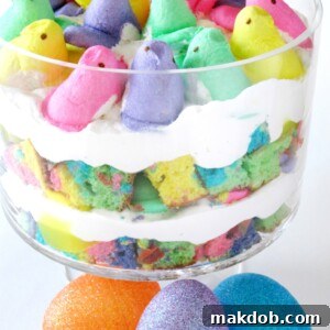 An image of a visually stunning rainbow Peeps trifle, layered with colorful cake, lemon pie filling, and whipped topping.