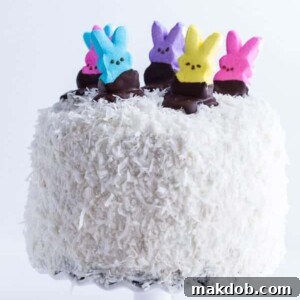 An image of a decadent coconut cake adorned with colorful Peeps on top.