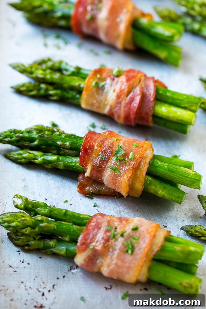 Beautifully roasted asparagus bundles, glazed and crispy, displayed on a sheet pan fresh out of the oven.