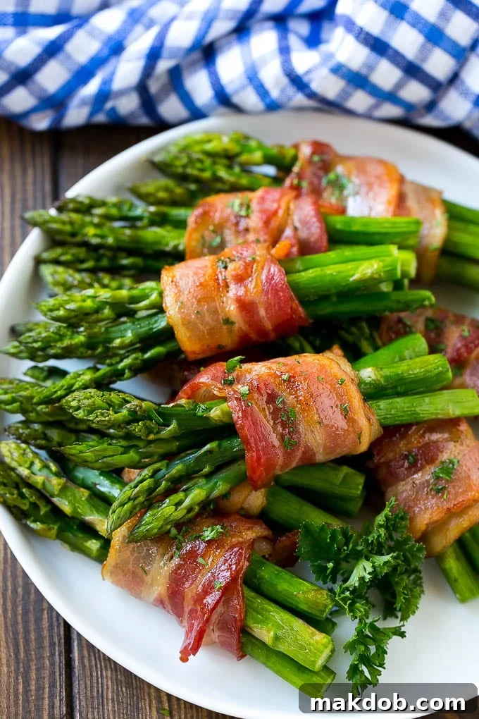 A stunning plate of roasted bacon wrapped asparagus bundles, perfectly cooked and garnished with fresh parsley.