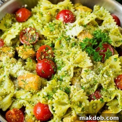 Chicken pesto pasta with cherry tomatoes and parmesan cheese.