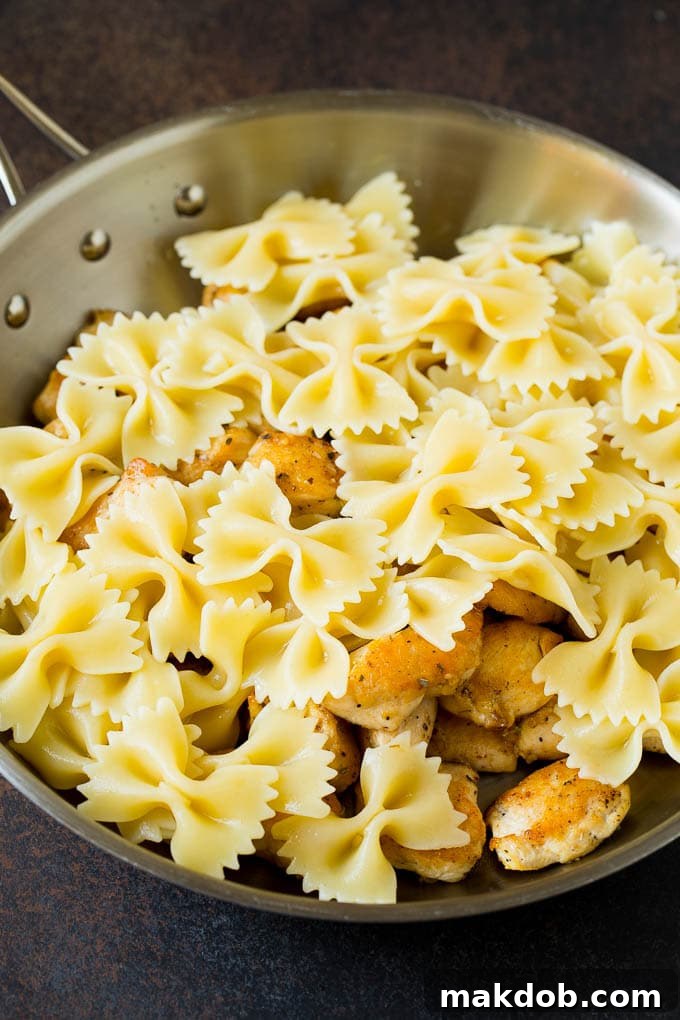 Chicken and farfalle pasta beautifully mixed in a pan.