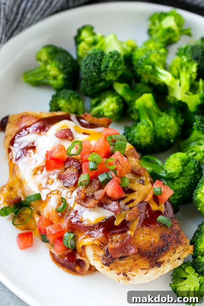 Monterey chicken covered in barbecue sauce, cheese, bacon and tomatoes, served with a side of broccoli.