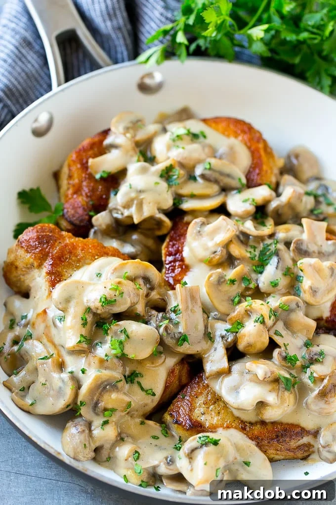 Mushroom Pork Chops Recipe | Boneless Pork Chop Recipe | Pork Chops with Mushroom Sauce #pork #porkchops #mushrooms #dinner #dinneratthezoo Mushroom pork chops in a skillet topped with creamy mushroom sauce and chopped parsley.