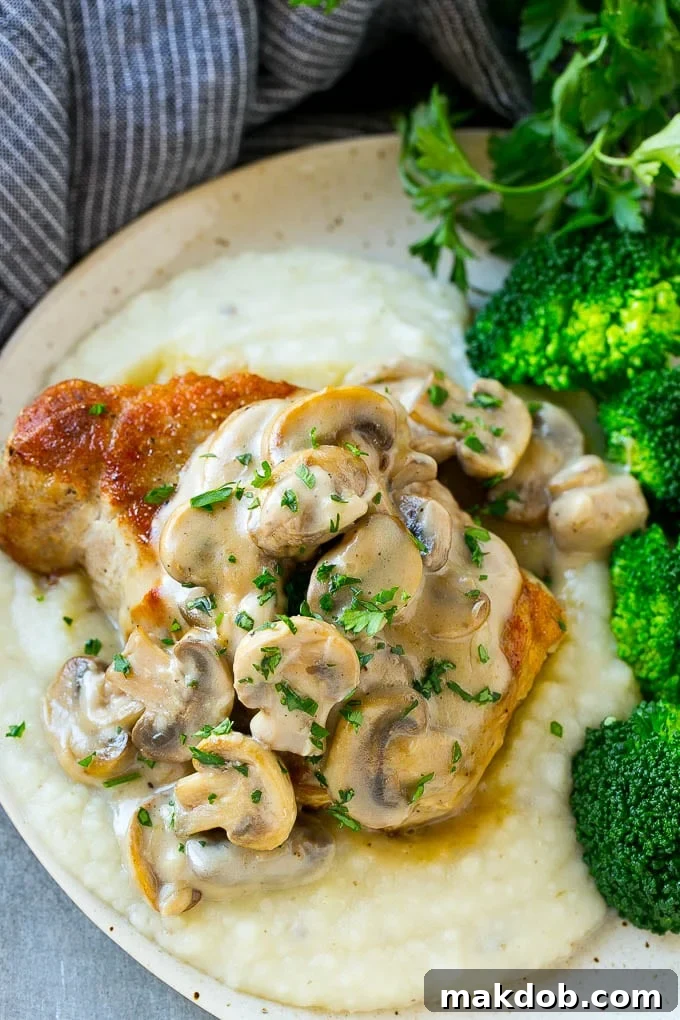 Mushroom Pork Chops Recipe | Boneless Pork Chop Recipe | Pork Chops with Mushroom Sauce #pork #porkchops #mushrooms #dinner #dinneratthezoo A pork chop with mushroom sauce served on mashed potatoes with a side of broccoli.