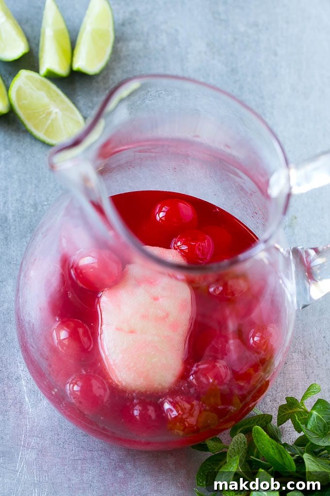 Limeade concentrate and maraschino cherries and juice in a pitcher. Limeade concentrate and maraschino cherries and juice in a pitcher.
