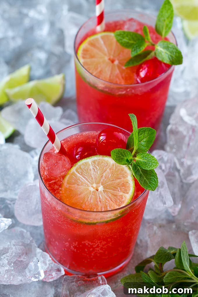 Cups of cherry limeade garnished with mint, lime and cherries. Cups of cherry limeade garnished with mint, lime and cherries.