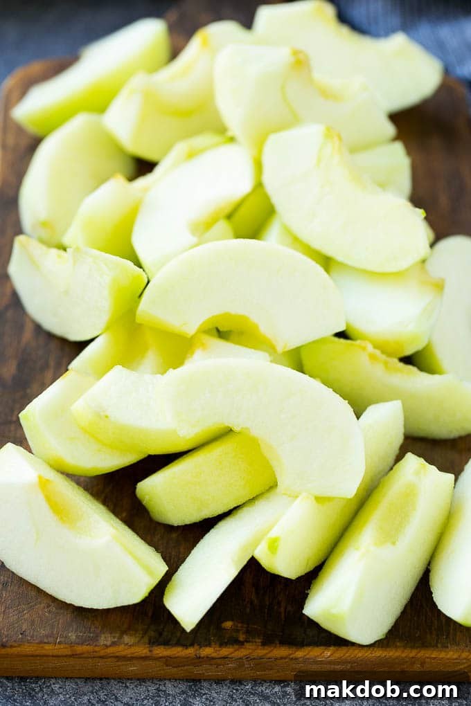 Freshly sliced Granny Smith apples, peeled and cored, ready for battering and frying into delicious apple fries.
