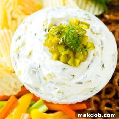 A bowl of dill pickle dip served with vegetables.