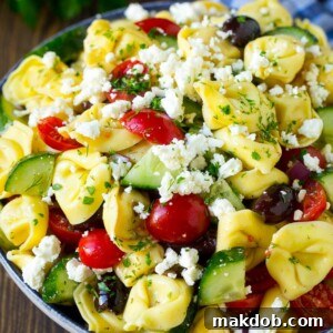 Tortellini salad showcasing tender tortellini pasta with crisp cucumber, ripe tomato, briny olives, and tangy feta cheese.