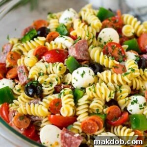 Italian pasta salad overflowing with rotini noodles, savory salami, zesty pepperoni, and an array of vegetables.