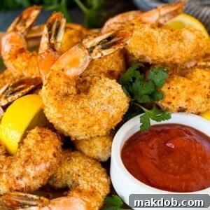 A plate of air fryer shrimp served with cocktail sauce.