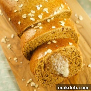 A loaf of brown bread on a wooden board.