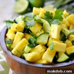A unique Pineapple Cucumber Salad served in a rustic wooden bowl, showcasing the refreshing combination of sweet pineapple and crisp cucumber.