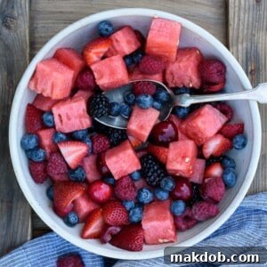 A delightful Berry Watermelon Fruit Salad, presented in a bowl with a mix of vibrant berries and juicy watermelon chunks, ideal for summer gatherings.