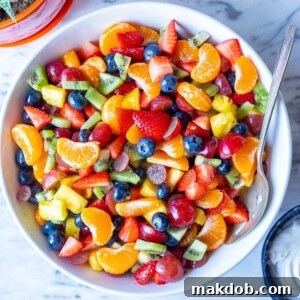 A colorful Rainbow Fruit Salad, bursting with grapes, blueberries, and other bright, appealing fruits, making it a healthy and fun snack.
