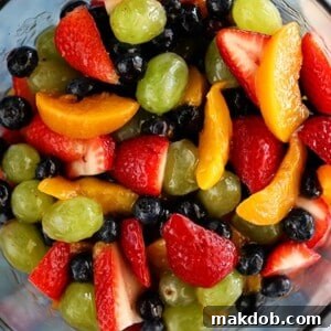 A intriguing Secret Ingredient Fruit Salad, showcasing a variety of vibrant fruits with a special addition of peaches, offering a unique and comforting flavor.