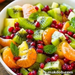 A vibrant Winter Fruit Salad, featuring a colorful assortment of fresh seasonal fruits, all tossed in a light and zesty honey poppy seed dressing.