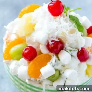 A classic Ambrosia Salad, rich with colorful fruit, fluffy marshmallows, and shredded coconut, all enveloped in a light, creamy dressing.