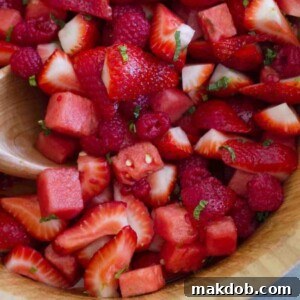 A visually stunning Crown Ruby Fruit Salad, highlighting an assortment of red fruits like juicy watermelon, sweet strawberries, and ripe raspberries for a vibrant summer dish.