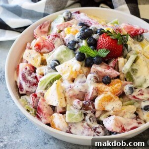 A luscious Creamy Fruit Salad, showcasing a medley of strawberries, kiwi, and other fresh fruits coated in a smooth, rich dressing for a delightful texture.