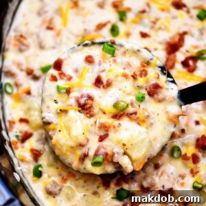 A pot of savory bacon cheeseburger soup, with a ladle showing its rich, creamy texture.