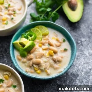 A creamy bowl of crock pot white chicken chili, beautifully topped with fresh avocado slices.