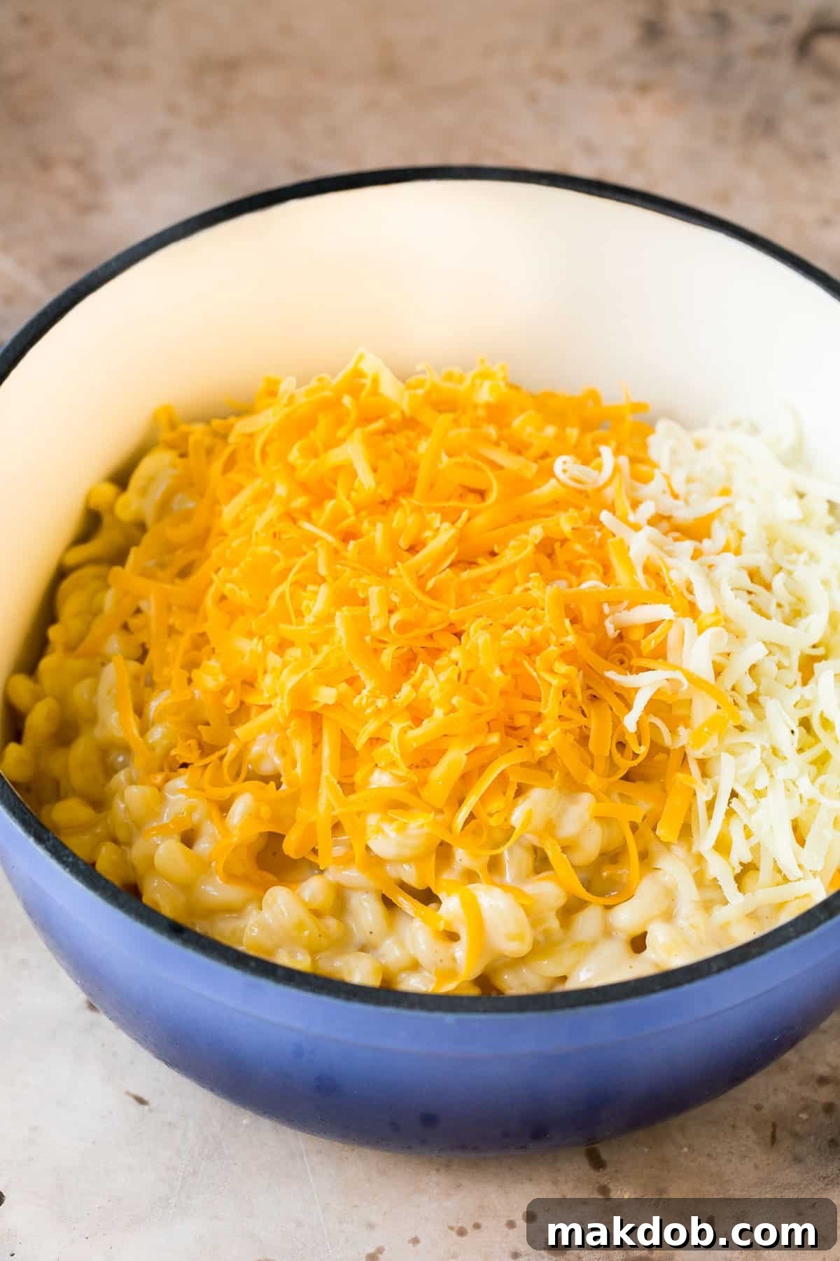 One-Pan Creamy Mac 5 Cooked noodles with two types of shredded cheese on top.