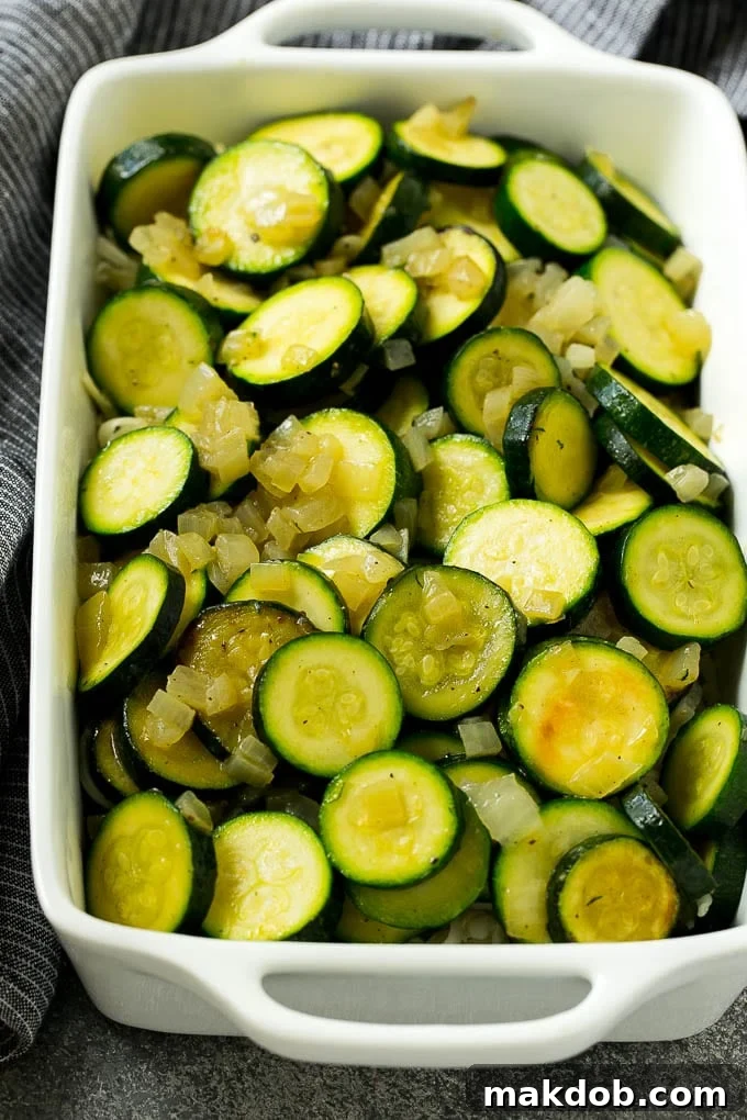 Zucchini Gratin Recipe | Cheesy Zucchini | Baked Zucchini | Easy Zucchini Recipe #zucchini #casserole #cheese #dinner #sidedish #dinneratthezoo Layers of sauteed zucchini and onions arranged in a baking dish, ready for sauce and cheese.
