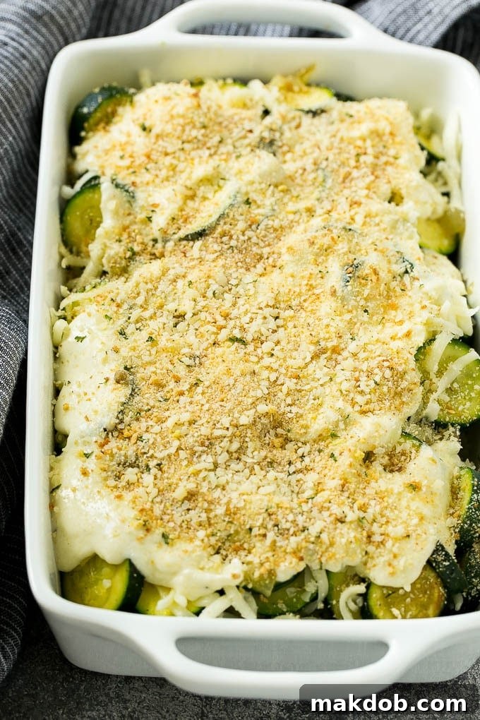 Zucchini Gratin Recipe | Cheesy Zucchini | Baked Zucchini | Easy Zucchini Recipe #zucchini #casserole #cheese #dinner #sidedish #dinneratthezoo Assembled zucchini gratin with perfect layers of cheese, creamy sauce, and seasoned breadcrumbs, ready for baking.