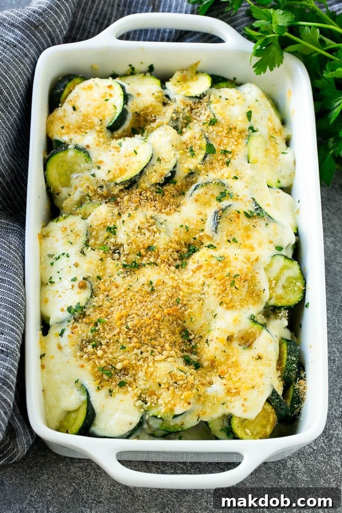Zucchini Gratin Recipe | Cheesy Zucchini | Baked Zucchini | Easy Zucchini Recipe #zucchini #casserole #cheese #dinner #sidedish #dinneratthezoo A freshly baked zucchini gratin in a dish, showing its golden crust, bubbling cheese, and vibrant green herbs.