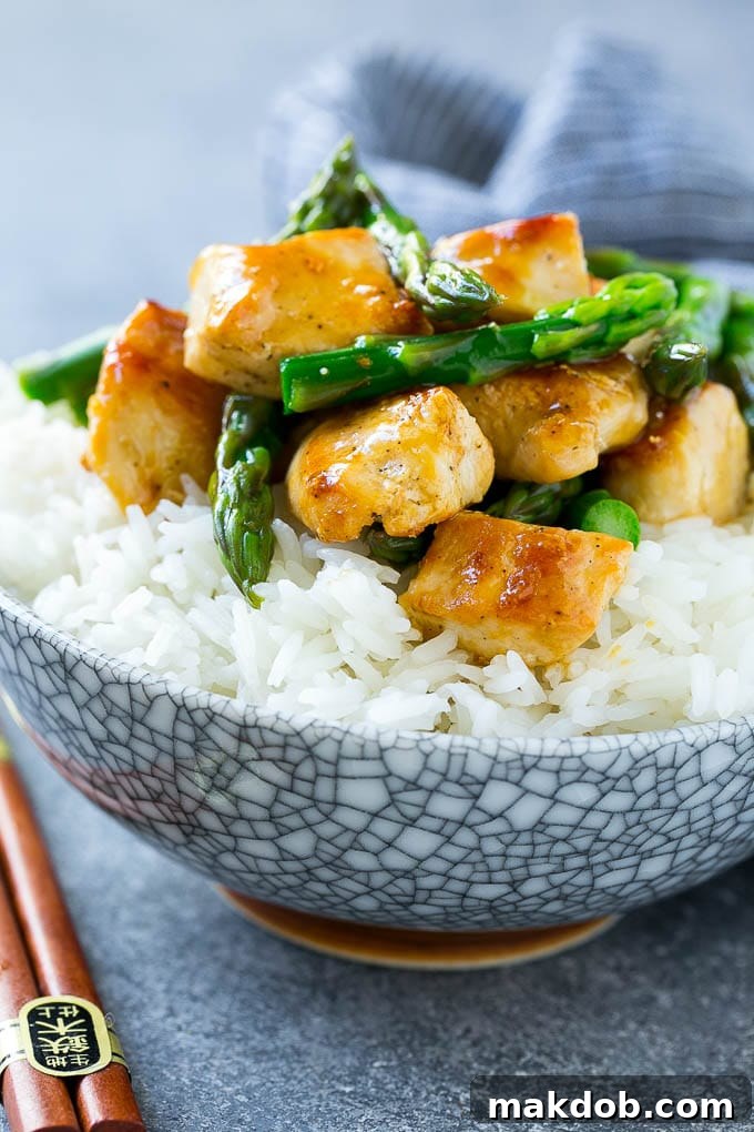 Speedy Chicken and Asparagus Stir Fry 5 A bowl of chicken and asparagus stir fry served over steamed rice.